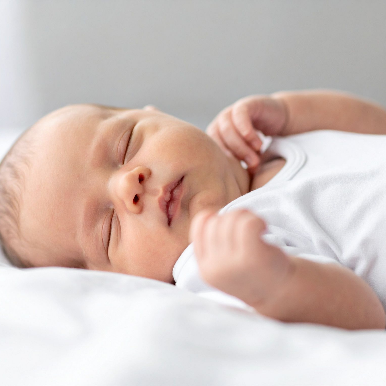 Peaceful newborn sleeping soundly in soft and cozy bedding